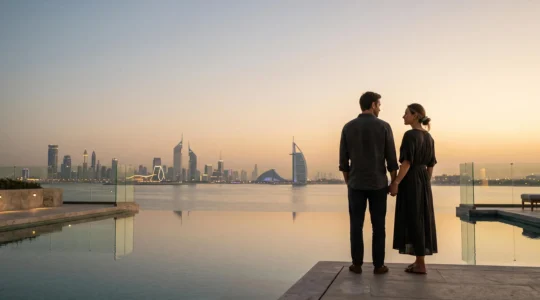 Couple silhouette au coucher du soleil face au skyline de Dubaï, symbolisant une lune de miel sereine et bien organisée